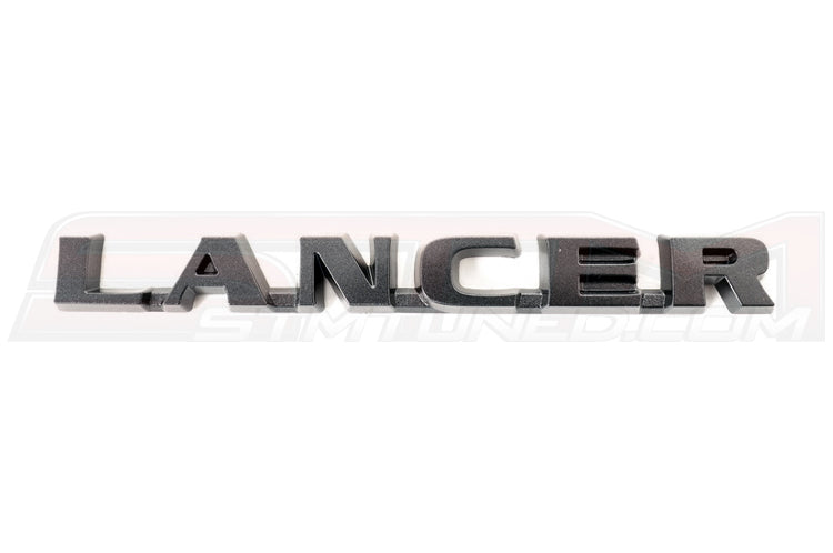 Mitsubishi OEM Evo 9 JDM Black Lancer Badge (7415A008) Image © STM Tuned Inc
