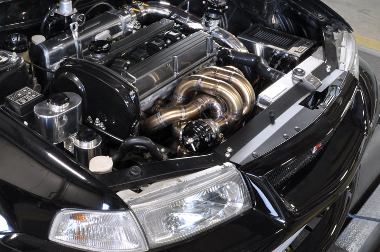 Forward Facing Turbo Exhaust Manifold installed on a black Evo 5
